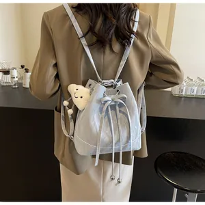 Detail of light blue drawstring bucket backpack with plush cloud charm and bow detail