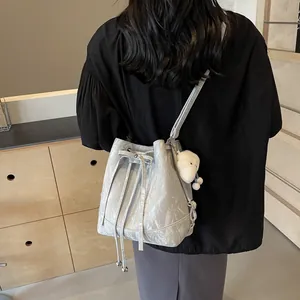 Fashionable grey drawstring bucket bag with marble texture and plush charm accessory