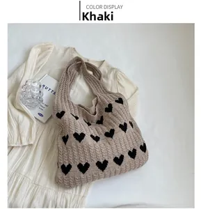 Detailed knit texture and black heart pattern on the khaki woven shoulder tote bag