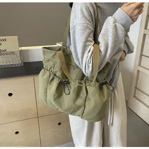 Detail van groene gewassen stoffen shopper met geplooide trekkoordzakken en geweven handvatten