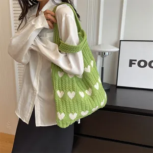 Green knitted tote bag with white heart patterns and wide shoulder strap