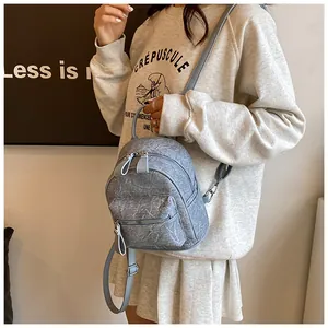 Détail du mini sac à dos bleu clair texturé dans un cadre lifestyle élégant