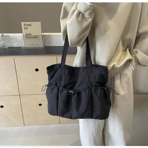 Detail van de zwarte stoffen shopper met een handige voorzak met trekkoordsluiting
