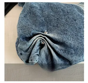 Detailed close-up of premium washed blue denim fabric texture and silver metal buckle