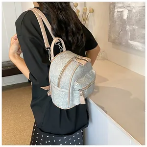 Détail d'un petit sac à dos bleu clair à motif marbré avec lanières en cuir beige