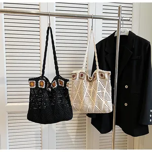 Detail of hand-crocheted shoulder bags with sunflower embroidery and hollow mesh patterns