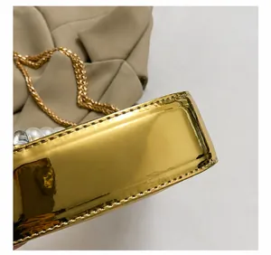 Dettaglio della borsa da sera in pelle dorata a specchio con perle e cuciture fini