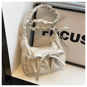 Detail of beige pleated shoulder bag with bow and ruffled strap texture macro