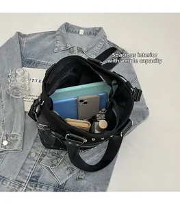 Top view of spacious interior in black studded crossbody bag with tablet and phone