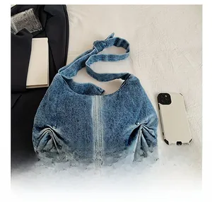 Detailed close-up of retro washed denim shoulder bag with white contrast stitching accents