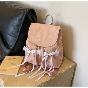 Detail view of the pink ballet-style backpack featuring white lace ribbons and Nika embroidery