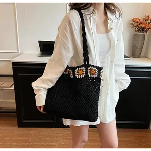 Detail view of black crochet tote bag featuring vibrant sunflower knit patterns and mesh texture