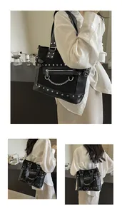 Close-up of black punk tote bag with silver studs, metal chains and decorative zippers