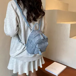 Mini sac à dos bleu clair à texture marbrée sur sweat gris et jupe plissée