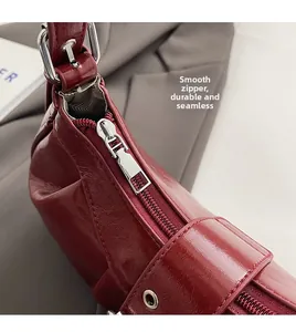 Detailaufnahme des glatten silbernen Reißverschlusses an dieser weinroten Vintage-Tasche