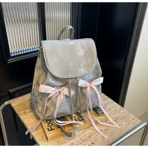 Detailed shot of silver backpack with pink satin bows and Nika embroidery on flap