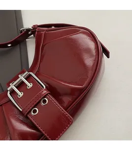 Nahaufnahme der weinroten Lackleder-Schultertasche mit silberner Metallschnalle im Vintage-Stil