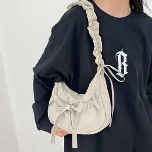 Beige crescent bag with ruffled strap and bow detail, casual minimalist shoulder bag