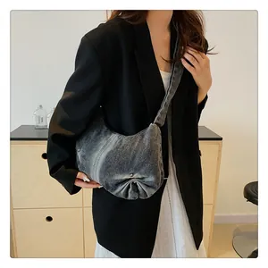 Detailed view of grey denim shoulder bag featuring unique pleated bottom and washed texture