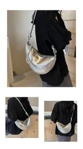 Detailed close-up of a silver hobo bag with knotted strap and metallic glossy finish