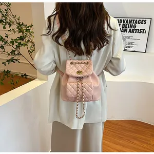 Detail of pink quilted mini backpack with chain straps shown on a model's back