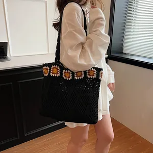 Black crochet tote bag with sunflower embroidery and mesh knit design for beach use