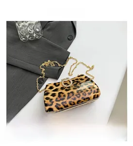 Detail of leopard print evening bag featuring glossy finish and rhinestone ring buckle