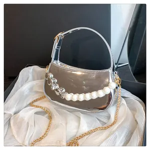 Dettaglio della borsa a mezzaluna argento specchiato con perle e catena a cuore