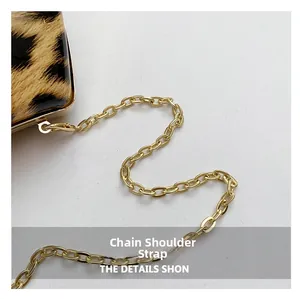 Detailed macro view of the premium golden metal chain strap on a leopard print evening bag