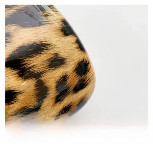 Macro shot of the high-gloss leopard print texture and polished finish on the clutch bag