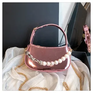 Dettaglio mini borsa rosa metallizzato con catena decorativa di perle e cuori argento