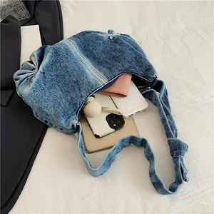 Ruched denim shoulder bag in washed blue with knot strap and large capacity