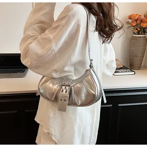 Detail der silbernen Metallic-Schultertasche mit Schnalle und Metallösen-Dekor