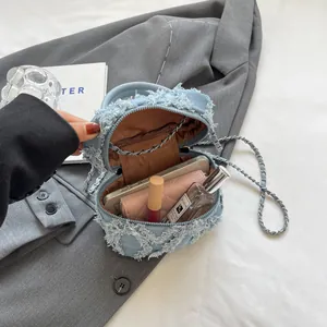 Light blue denim chain bucket bag with distressed floral design and spacious interior