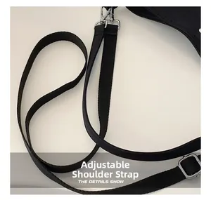 Detail of black adjustable canvas shoulder strap with silver metal swivel hooks and buckle