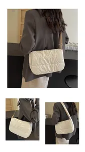 Détail du sac bandoulière matelassé blanc avec coutures parallèles et sangle réglable