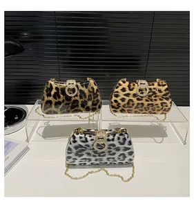 Detailed view of three leopard print evening bags with crystal rings and chain straps