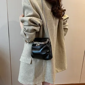 Sac docteur en cuir noir classique avec fermoir métallique et chaîne argentée porté par modèle