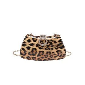 Detail of leopard print evening clutch with gold chain and rhinestone double-ring clasp