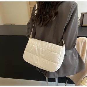 Détail du sac bandoulière matelassé crème avec texture rembourrée et large bandoulière