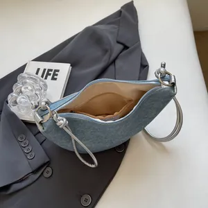 Light blue denim crescent bag with silver circular handle and long shoulder strap
