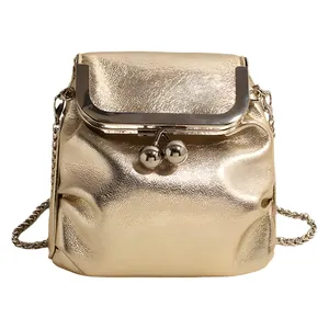 Sac à main doré élégant avec bandoulière en chaîne et fermoir rétro sur fond blanc