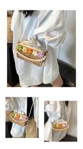 Detail of hand-woven straw bag featuring knit flowers and elegant pearl strap accents