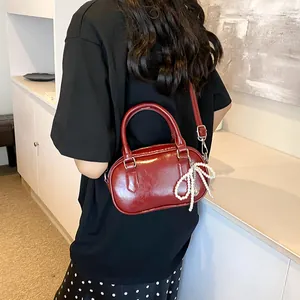 Minimalist burgundy PU leather crossbody bag with elegant pearl bow charm accessory