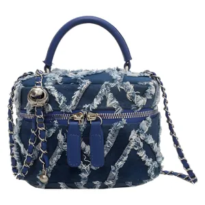 Blue denim bucket bag with frayed edges, silver chain strap and top handle
