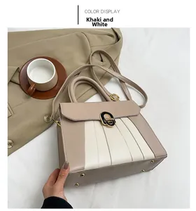 Detail der khaki-weißen PU-Tasche mit Falten und Goldschnalle auf beige Anzug-Hintergrund