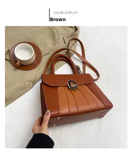 Detailansicht der braunen PU-Tasche mit Metallschnalle und goldenen Standfüßen