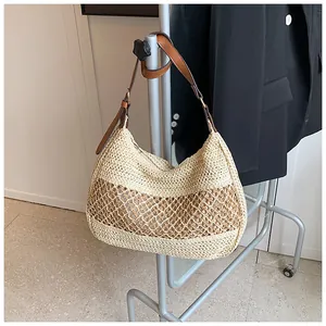 Detail of hand-woven straw hobo bag with brown mesh insert and leather shoulder strap