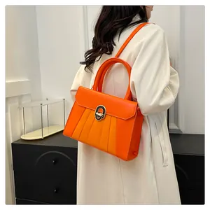 Detailansicht der plissierten orangen PU-Ledertasche mit goldenem Drehverschluss