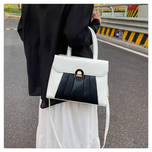 Detailansicht der zweifarbigen PU-Lederhandtasche mit Goldverschluss und Falten-Design